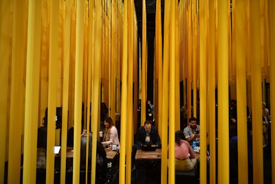 Canadian interbank network Interac featured a lounge created with bands of hanging fabric in the company's shade of yellow. Inside the lounge, tables, chairs, and charging stations were provided for impromptu meetings. In another space, Interac employees gave demos of the brand's technology and services. The lounge was produced by creative agency Zulu Alpha Kilo in partnership with event design and build company Astound.