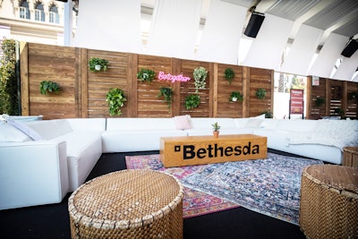 The party included airy seating areas with white couches, hanging greenery, and neon signage. The Bethesda logo was printed on coffee tables throughout the space, which included tenting by Choura Events.