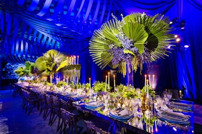 “The dining scene was set with elaborate custom draping and [the company’s] Berlin rectangular and square chrome dining tables were topped with glowing candles and centerpieces. Patterned china, gold flatware, and lush florals were reflected on the mirror-top tables for the intimate gathering. The tables reflected the abundance of textured greenery and candlelight that filled the tablescape.” Pictured: Zamora and husband Celio De Almeida’s second anniversary party