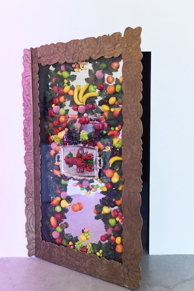 A mirrored door was decorated with faux fruit and a lobster, drawing inspiration from the Surrealism movement.