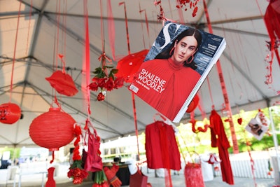 A hanging mixed media installation in an outdoor tent used red items such as CDs, Chinese lanterns, magazines, and old items of clothing.