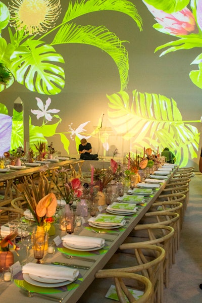 The layout and design of the party, designed and produced by the museum’s in-house event team led by Tania Abitbol, was inspired by tropical flowers in light shades of pastel lavender, rose pink, cantaloupe, and lime green. Pastel tropical foliage was used on the tables, accented by custom neon Lucite chargers with a lavender Anthurium print. The carpet, tables, and chairs were a neutral shade of ecru. Projections of tropical foliage completed the look throughout the space.
