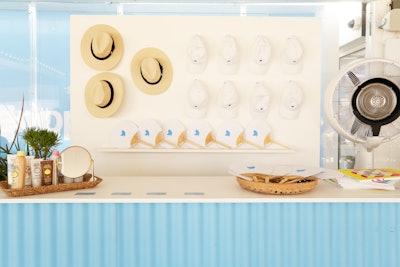 A merchandise station offered branded fans, baseball caps, and beach hats.