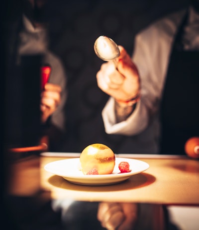 Hand-blown golden spheres filled with fresh raspberries, raspberry mousse, and fresh edible flowers, by Wolfgang Puck Catering in Atlanta, Boston, Dallas, Houston, Los Angeles, Philadelphia, Seattle, and Washington