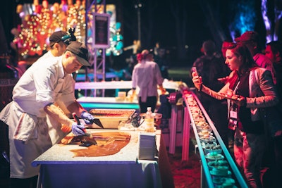 Dark, milk, and white chocolate slabs with toppings such as seeds, dried fruit, and nuts flash frozen with nitrogen and smashed with mallets, by Wolfgang Puck Catering in Atlanta, Boston, Dallas, Houston, Los Angeles, Philadelphia, Seattle, and Washington