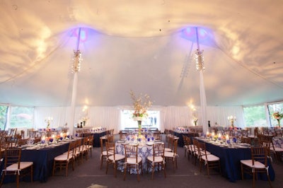 Tent ceiling uplighting for a private party with tent pole and table art