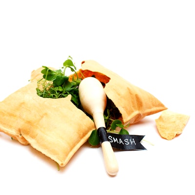 Edible pillow cracker filled with a composed salad smashed using a mini wooden maraca, by Pinch Food Design in New York