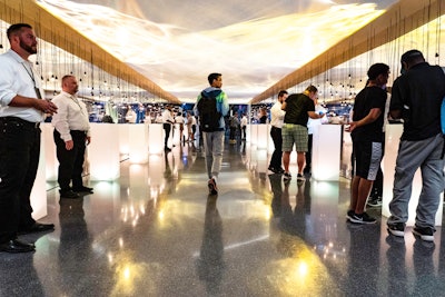 A room of product displays featured high-tech and low-tech audiovisual elements including ceiling projections and hanging lightbulbs.