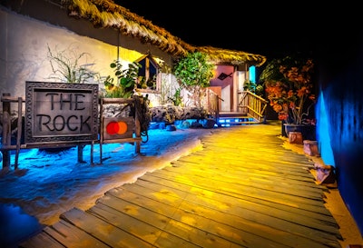 Mastercard brought on Adirondack Studios to design a replica of the Rock in Zanzibar. Guests enter the venue on a boardwalk over sand, surrounded by tropical plants, recalling the original location of the restaurant, which is owned by Nigel Firman.