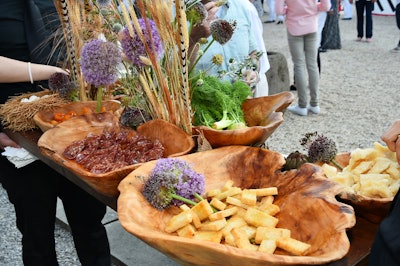 Catered by Bite Food, the passed hors d'oeuvres came in the form of elaborate beach-theme 48- by 18-inch trays that featured small bites intrinsic to the event's Hamptons environment. Here, 'Meadow' featured allium blossom, fennel, and wheat frond decor with fried baby artichokes, quail eggs, parmesan shards, honey apricots, and semolina croustades.