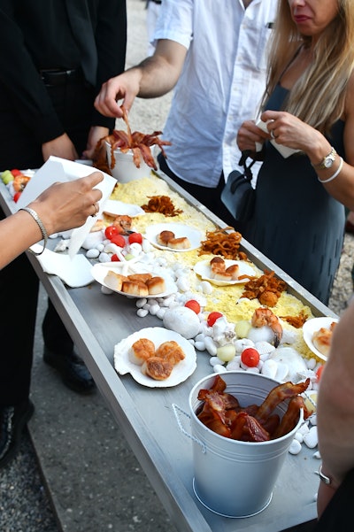 A beach-theme tray, catered by Bite Food, featured little tin pails and white stones and shells among scallops, crispy clams, bacon rashers, multi-color melon balls and sweet corn croquettes.