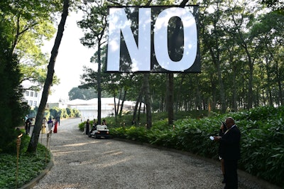 This year's benefit, titled 'Tabula Rasa' and presented by Van Cleef & Arpels, welcomed more than 1,000 guests. Situated at the entrance off Water Mill Towd Road, hanging over the driveway, was Spanish artist Santiago Sierra's 'No' flag—beginning with the suggestion of refusal, while not targeted or specified.