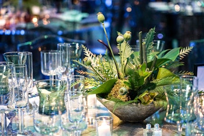 Tropical green centerpieces by Blue Vanda Designs evoked the prehistoric jungle theme, even using ferns that can be seen in fossils.