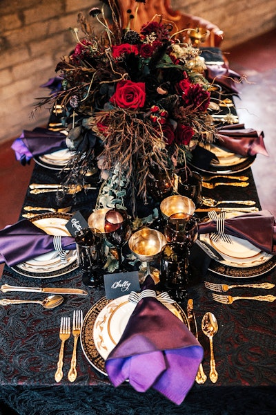 The shoot included a moody tablescape with black and red linens and purple napkins from Luxe Linen. Bridezilla Events handled floral design, while tabletop rentals came from Dish Wish and furniture rentals came from La Piñata Party Rentals.