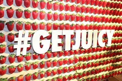 At a custom speakeasy-style bar, the front was covered in glittered strawberries and the campaign hashtag.