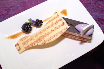 Food For Thought catered the event, providing a lavender opera cake for dessert. Made with almond cake, lavender ganache, and blackberry meringue, the treat was garnished with musical notes on a sliver of white chocolate.