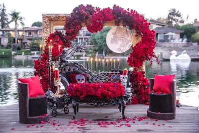 For a private Halloween party planned by Event Du Jour in 2017, Revelry Event Designers created a dramatic vignette featuring a large candelabra, skeleton pillows and props, black furniture rentals, and an abundance of deep red roses from Celio's Design.