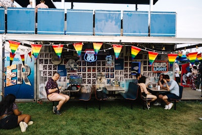Bud Light brought its traveling Dive Bar activation to Governors Ball in New York for the first time in June. The back of the Bud Light Dive Bar activation featured imagery welcoming guests, along with dive bar-inspired decor and seating. The wall was plastered with vintage Bud Light ads and neon signs.