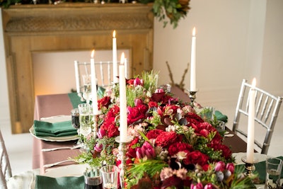 Event design agency B Floral designed this festive tablescape with a mix of blooms such as roses, tulips, and Calla lilies in shades of red and purple.