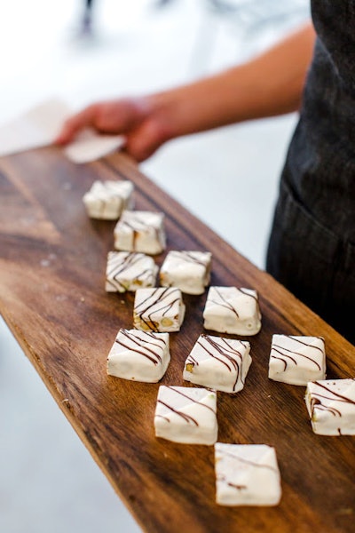 Serve squares of white chocolate pistachio torrone with dark chocolate drizzle from Schaffer in Los Angeles.