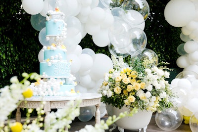 For a first birthday party in Los Angeles in April 2018, C Rezende Events created an extravagant design out of something quite simple: rubber ducks. The outdoor event was decked in on-theme yellow, white, and blue colors, and decorated with giant kid-friendly props and plenty of balloons. Every aspect was designed to tie into the 'Rubber Duckland' theme, including a specialty cocktail, the DJ set list, the food presentation, and even the staff outfits. One eye-catching highlight was the event's dessert table: A vintage bathtub was turned into a huge flower centerpiece, and clear balloons were used to resemble bubbles. A large blue birthday cake also adopted a bathtub theme, with bubbles and more rubber ducks.