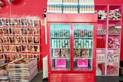 The raw space was transformed by HL Group’s event team with nods to the classic New York City bodega, including fridge cases that served as product display areas, branded grocery items like water bottles and paper towels, and hot pink milk crates. A newsstand-inspired step-and-repeat built with custom-branded magazines became a natural photo moment for guests.