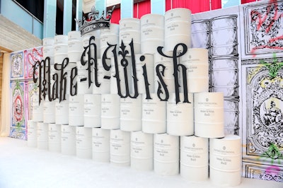 Gothic lettering displayed on tiered, painted barrels served as an arrivals wall.