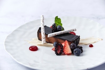 Chocolate ganache tart with shards of coffee meringue and salted caramel crème fraîche, garnished with strawberries, blueberries, and blackberries, by Abigail Kirsch in New York
