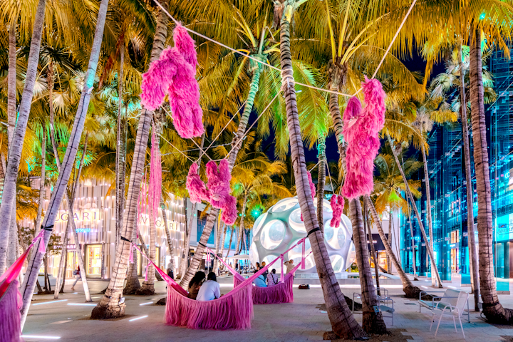 London-based Mexican designer Fernando Laposse was selected by the 2019 Neighborhood Commission in the Miami Design District to present his “Pink Beasts” installation, featuring sloths hanging from ropes, trees, and arches.