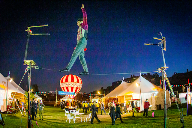 The experience immersed guests in an 1862 Victorian carnival, referencing the fair where the film's characters first set out on their balloon journey. More than 50 costumed performers included a tightrope walker, a juggler, and an aerial acrobat dangling from a tether line.