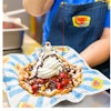 Bullet Funnel Cake topped with vanilla soft serve, strawberry fruit toppings and chocolate sauce