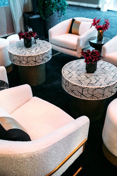 Mercedes-Benz USA's annual Oscars viewing party in February, designed and produced by Sterling Social, had a dark, contemporary aesthetic using tonal layers of black accented with pops of ivory, gold, and brass. In a lounge area, furniture groupings included cream boucle upholstered chairs and graphic black-and-white herringbone inlaid and brass coffee tables.