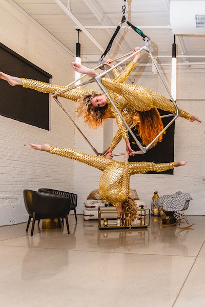 As added entertainment, dancers donning gold spike-clad suits were suspended from the ceiling on a custom cube trapeze.