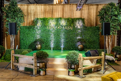 A wall of green foliage served as a photo backdrop for guests and nodded to the event's original Irish countryside theme.