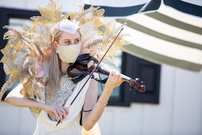 A violinist—in a stylish face mask, of course—entertained students and others waiting in their cars.