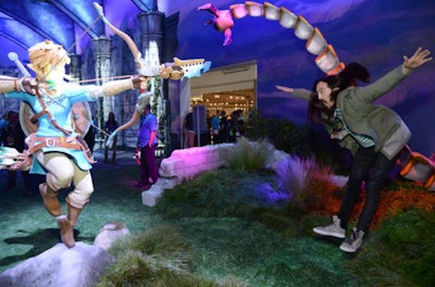 Nintendo's exhibit included backdrops and arched set pieces that resembled a castle to promote its latest in the Zelda franchise: The Legend of Zelda: Breath of the Wild. Similarly, a green grass-like floor sprawled underfoot, and trees and foliage decorated the area, including under gaming stations, for a lush outdoor look. Within the exhibit, celebrities like DJ Steve Aoki posed with life-size interactive set pieces that mirrored elements from the game. See more: 22 Ways Exhibitors Got Attention on the E3 Show Floor