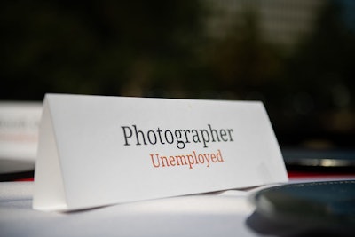 Place cards designating different event industry professions, each labeled as 'unemployed,' adorned the tables.