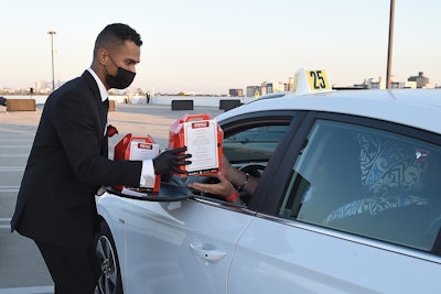 All attendees were required to wear masks if exiting their vehicles and undergo temperature checks and COVID-19 health screenings. Once the cars parked, men in suits delivered Bachelorette-themed swag, red roses, and snacks to enjoy while watching the season premiere.