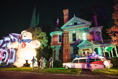 The sold-out drive-through featured a mix of props, fog machines, projection mapping, and actors who interacted with attendees (from a safe distance, of course), with highlights like the Addams Family mansion, a Ghostbusters scene, and a prize wheel inspired by The Nightmare Before Christmas. There were also in-car photo ops—including a fun green-screen experience that placed cars atop Spiral Hill—and bags of candy distributed with long poles.