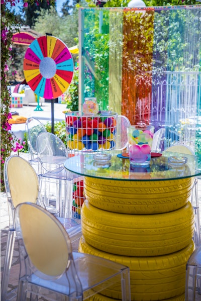 Themed 'inner child,' this 30th birthday celebration planned by My Event Design featured colorful, creative takes on highboy tables, like stacked yellow-painted tires and caged toy balls.