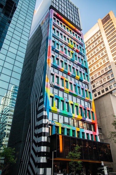 The artist had to work on a platform suspended from the roof of the hotel to apply the 80 different colors.