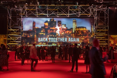 The large-scale benefit requires a long list of vendors to pull it off, said Stark. “There are literally hundreds of talented, committed, passionate people involved, so it’s impossible to name them all—from the house union teams that are always so proud of what we collectively build to Atomic Design, who supports the creative vision; Michael Fiur who helps with talent logistics and the live show; and Sarah O’Gleby, who creates immersive entertainment to aid our transitions from cocktails to dinner and then back again for the concert. Work-Order and Cottage 8 Films joined the team for the first time this year to help with the show graphics and videos, while Union Square Events served delicious fare, Drape Kings draped for miles, Dimitri Carpets carpeted for miles, and Event Associates [handled] ticketing and seating the thousands of guests. None of this happens without everyone’s contributions.”