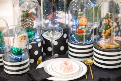 Festive figurines sit under cloches at Ghislaine Viñas's tablescape.