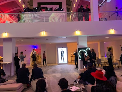 English musician Maxim of the electronic dance band The Prodigy addressed a crowd of partygoers at the Monolith, a 24-foot-tall NFT art exhibition space produced by ArtRepublic that featured works curated by SuperRare, from his home in London.