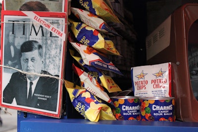 The newsstand was filled with authentic props, including iconic JFK and Lee Harvey Oswald magazine covers from 1957 to 1963, along with refreshments and candy. A vintage Zenith TV played NBC news footage from November 1963.