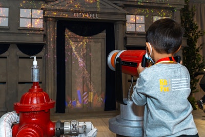 Also on-site is an interactive activation where kids grab a fire hose and 'douse' a colorful projection of out-of-control fireworks in a recreation of the show's City Hall.