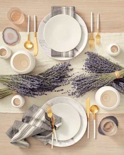 The Provence tablescape from Social Studies ($42 per place setting) boasts a subtle mix of marbleized melamine and white ceramic plates with gray and white linen napkins that allow the bundles of dried lavender to pop with periwinkle buds. The lavender is available for an additional charge.