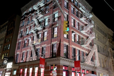 Outside, passersby on Spring Street were able to watch the 3D animated projection that scaled both sides of the historic building. The building appeared to be breaking apart and then reforming in the brand’s signature red and white patterns. See the projection mapping in action.