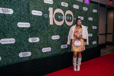 The step-and-repeat featured branded placards against a green wall.