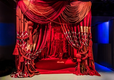 With a patchwork of quilts, Dan Mazzarini of BHDM Design created a vignette featuring an abundance of rich red draping to recall the gathering at the National Mall in 1987, which recognized those that lost their lives to HIV/AIDS.